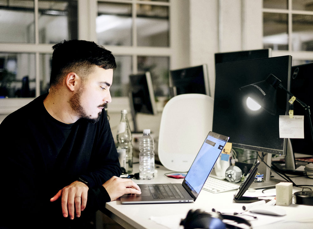 Man werkt op een laptop aan een bureau in een kantoor