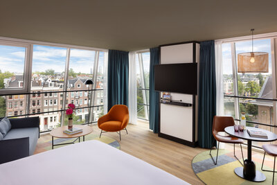 Avani_Museum_Quarter_Amsterdam_Hotel_Rooms_Junior_Suite_Panoramic_Canal_View_Queen_Bed_Siting_Area_TV_Flowers