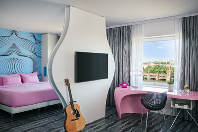 nhow_Berlin_Room_junior_suite_curtains_open_king_size_bed_guitar_tv_view_01