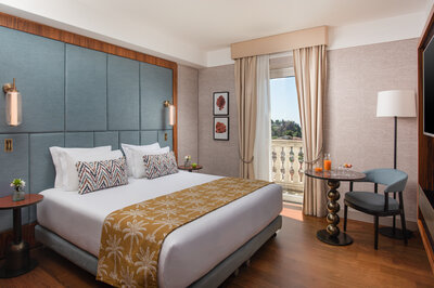 NH_Collection_Taormina_Room_Deluxe_View_Bed_Curtains_Open