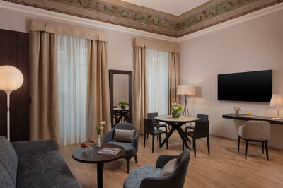 NH_Collection_Palazzo_Sitano_Room_Suite_Affresco_Living_Area_Couch_Table_Chairs_TV.jpg