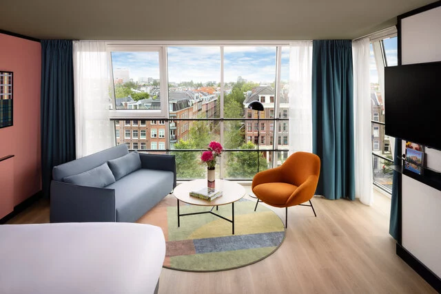 Avani_Museum_Quarter_Amsterdam_Hotel_Rooms_Junior_Suite_Panoramic_Canal_View_Queen_Bed_TV_Siting_Area