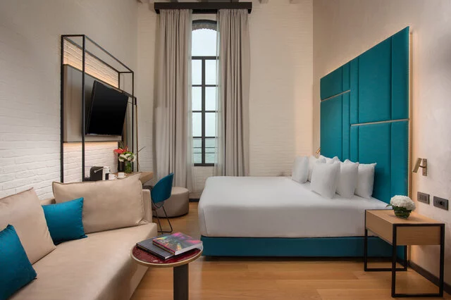 NH_Collection_Murano_Villa_Junior_Suite_Room_Laguna_Views_Bed_Pillows_Window_TV_Flowes_Table