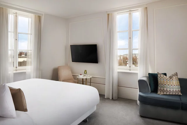 Tivoli_Doelen_Amsterdam_Guest_Room_Junior_Suite_King_size_bed_Sofa_pillows_Flatscreen_tv_Canal_view_water_setup-8688x5792