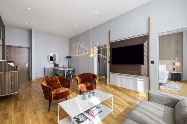 NH_Collection_Copenhagen_Room_Suite_Living_Area_TV_Sunlight_View_To_Bedroom_Dining_Table-8192x5464