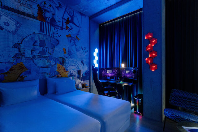 nhow_Frankfurt_Room_Gaming_blue_dark_bed_desk_side_view.jpeg