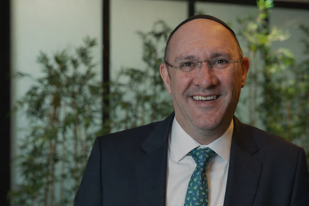 Smiling man in a sleek suit.png