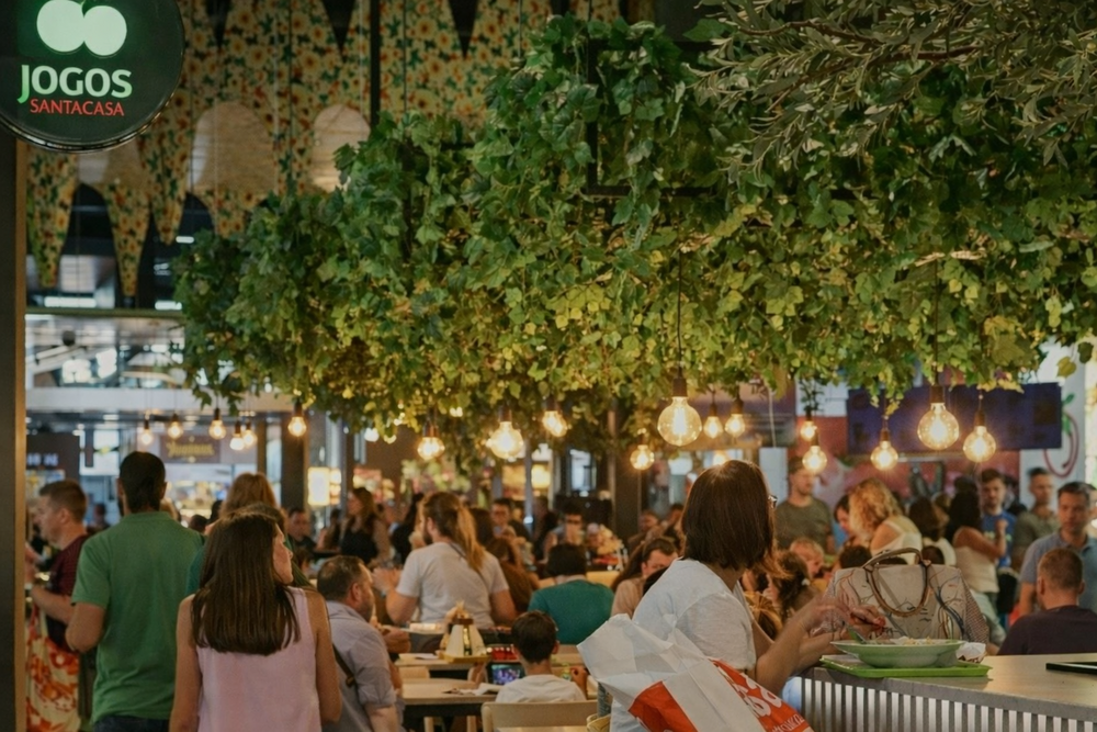 Lively food court with greenery and lights.png